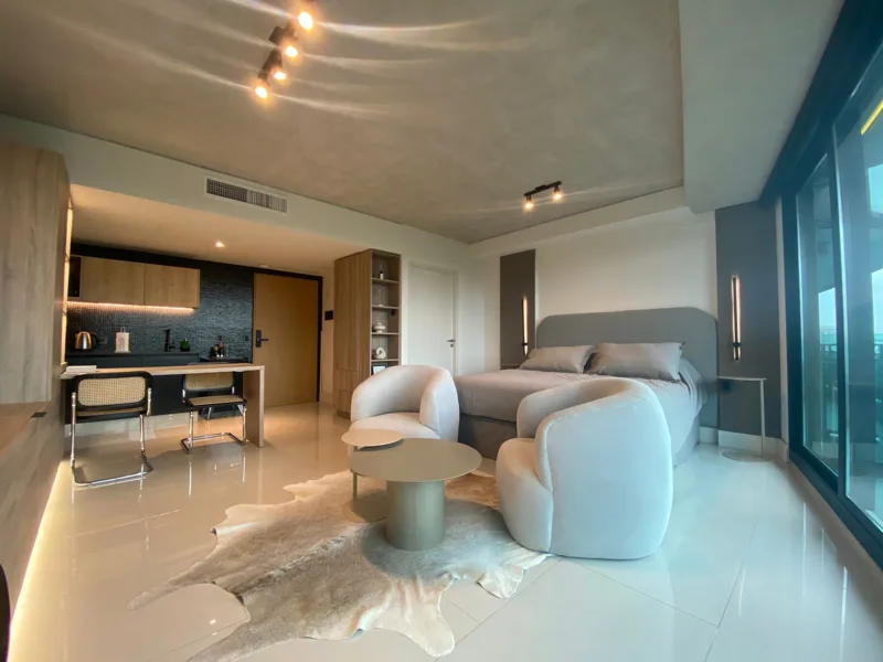Luxury living area, with curved armchairs and warm wood finishes
