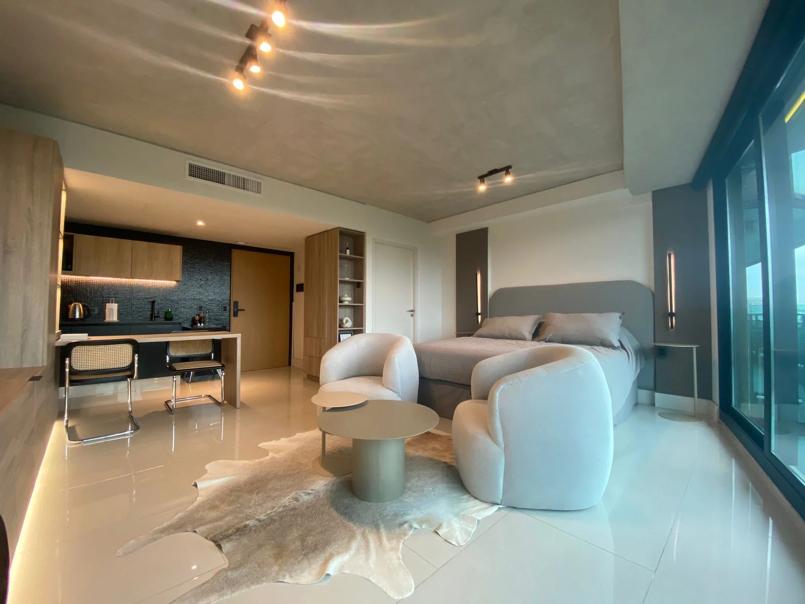 Luxury living area, with curved armchairs and warm wood finishes