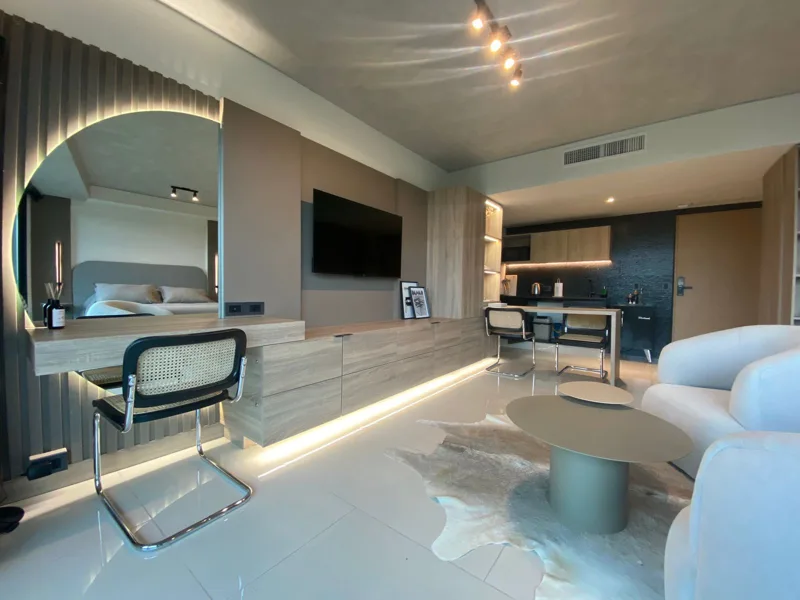 Luxury interior with illuminated mirror, desk and kitchen area